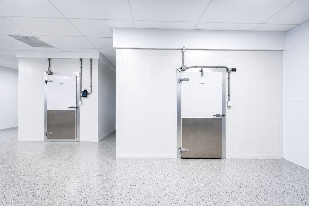 Chambres froides industrielles blanches avec portes isolées, plancher propre et environnement réfrigéré professionnel.